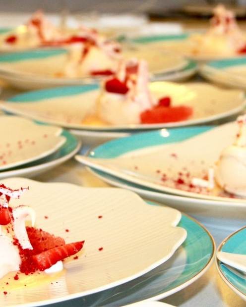 Individual pavlovas with strawberries and cream lined up for guest service aboard a superyacht