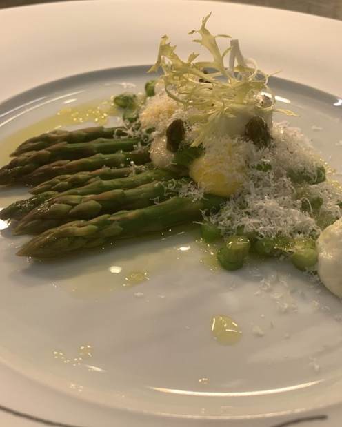 Asparagus with shaved parmesan and hen's egg, elegant vegetable course at sea