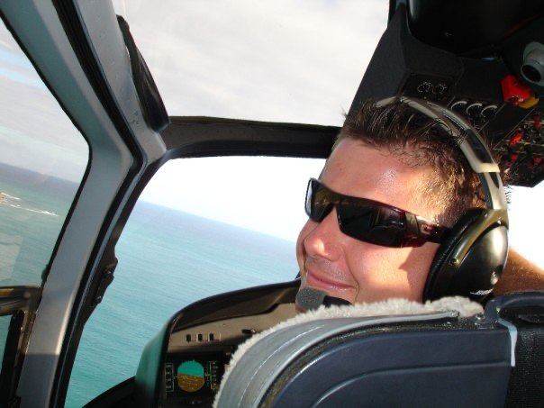 Troy in a helicopter over the ocean